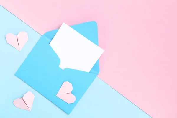 Голубой бумажный конверт и сердца на красочном фоне — стоковое фото