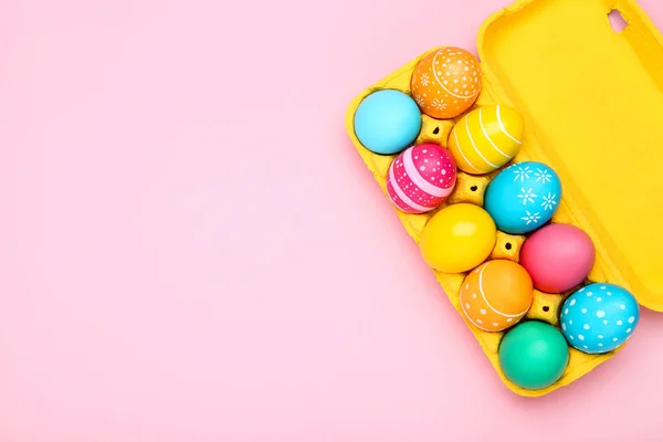 Huevos de Pascua coloridos en caja de cartón sobre fondo rosa —  Fotos de Stock