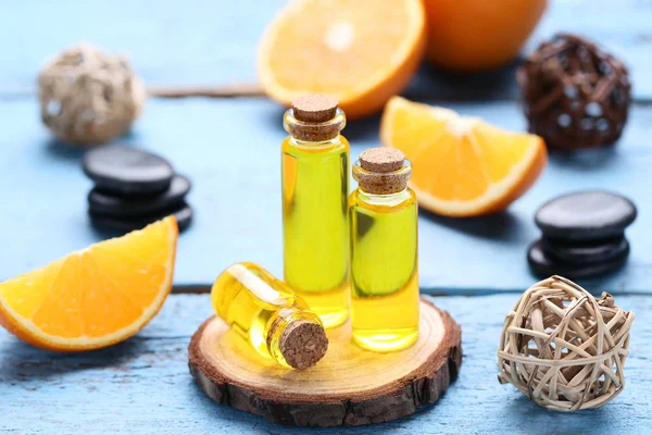 Aceite de naranja en botellas sobre mesa de madera azul —  Fotos de Stock
