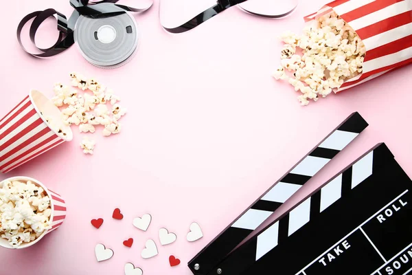 Tablero Clapper con cinta adhesiva y palomitas de maíz sobre fondo rosa — Foto de Stock