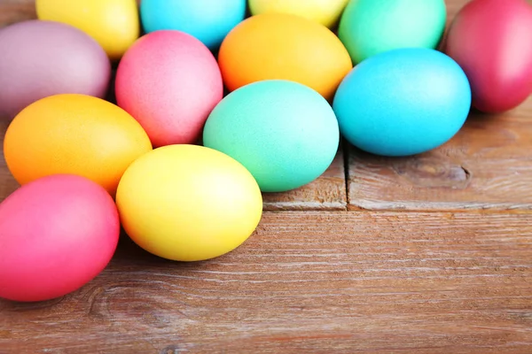 Ovos de Páscoa coloridos na mesa de madeira marrom — Fotografia de Stock