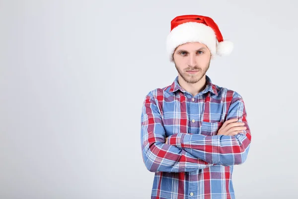 Молодий чоловік у капелюсі Санта на сірому фоні — стокове фото