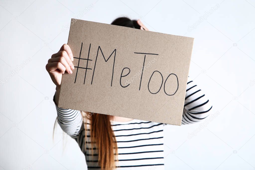 Woman holding paper with text Me Too on grey background