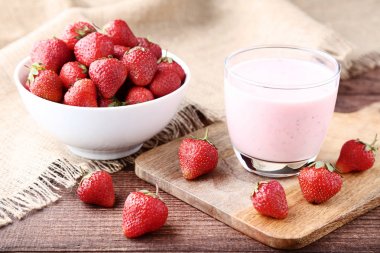 Kahverengi ahşap masa üzerinde çilek ile Smoothie