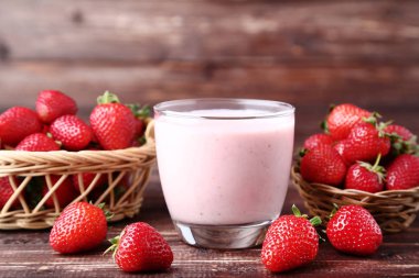 Kahverengi ahşap masa üzerinde çilek ile cam Smoothie