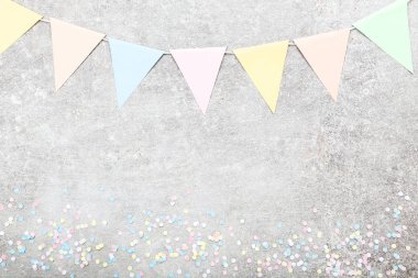 Renkli konfeti ve kağıt bayrakları gri arka plan üzerinde