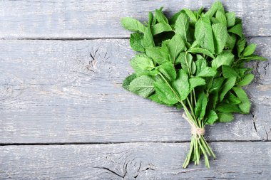 Gri ahşap masada nane yaprakları