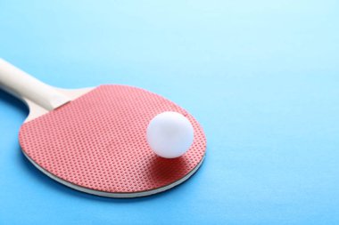 Mavi arka plan üzerinde topu ile masa tenisi raket