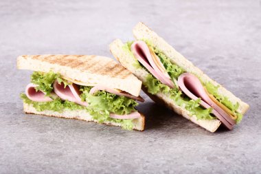 Jambon, peynir ve gri arka plan üzerinde sebze sandviç