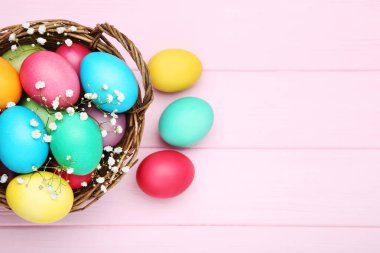 Paskalya yumurtaları ile ahşap masaya gypsophila çiçek sepeti