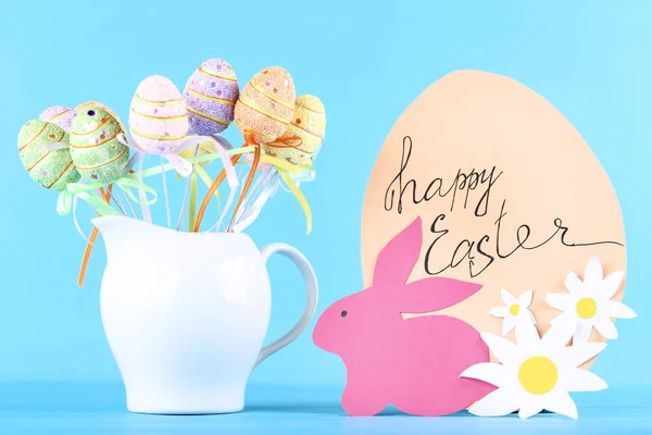 Paper rabbit with flowers, colorful eggs and text Happy Easter o