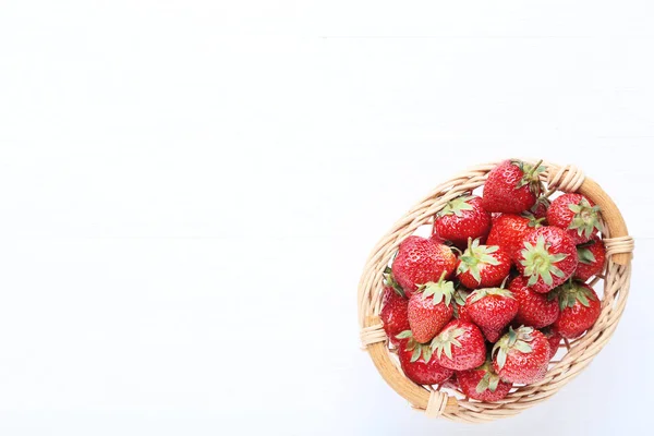 Frische Erdbeeren im Korb auf weißem Holztisch — Stockfoto