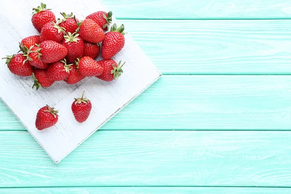 Frische Erdbeeren mit Schneidebrett auf Holztisch — Stockfoto