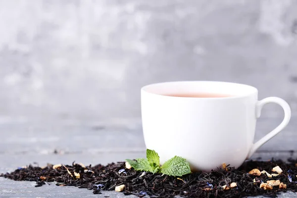 Tasse Tee mit Minzblättern auf grauem Holztisch — Stockfoto