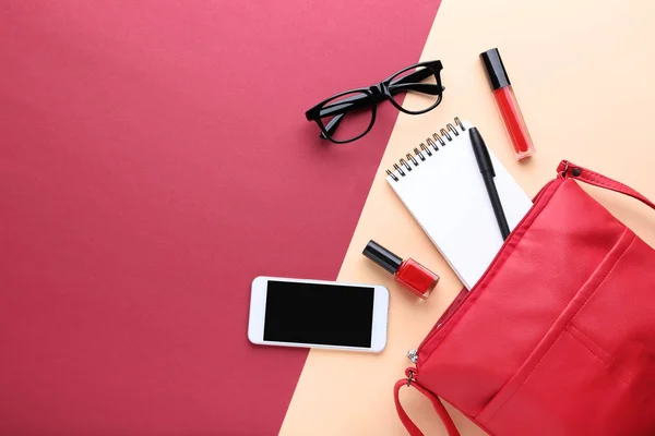 Bolsa com cosméticos, smartphone e notebook nas costas coloridas — Fotografia de Stock
