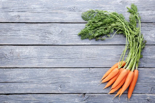Fresh carrot on grey wooden table — Stock Photo, Image