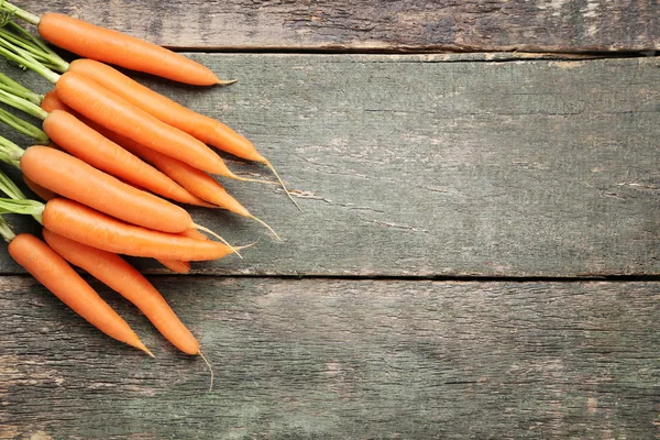 Fresh carrot on grey wooden table — Stock Photo, Image