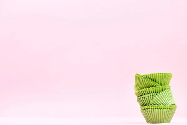 Чехлы для кексов на розовом фоне — стоковое фото
