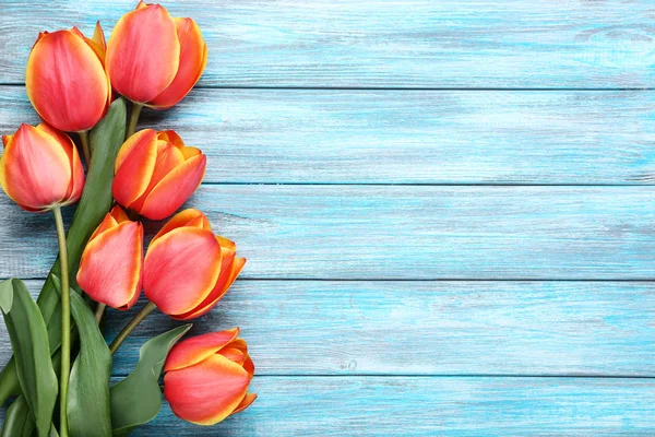 Bouquet of tulips on blue wooden table — Stock Photo, Image