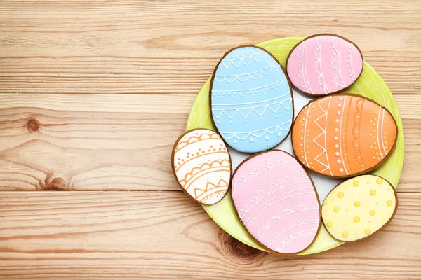 Easter gingerbread cookies in plate on brown wooden table — Stock Photo, Image