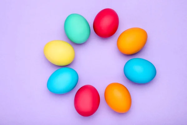 Барвисті великодні яйця на фіолетовому фоні — стокове фото