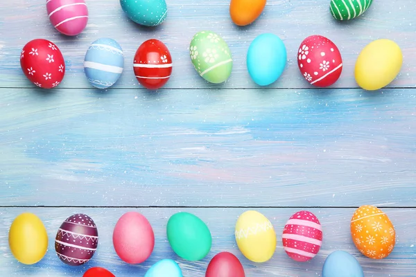 Huevos de Pascua coloridos en mesa de madera azul — Foto de Stock