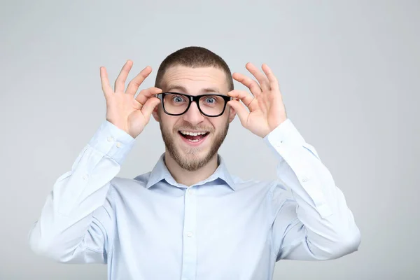 Porträtt av ung man med glasögon på grå bakgrund — Stockfoto