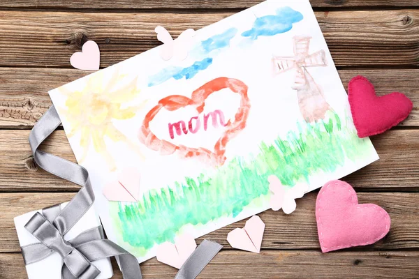Grußkarte zum Muttertag mit Geschenkbox und Herzen auf Holz — Stockfoto