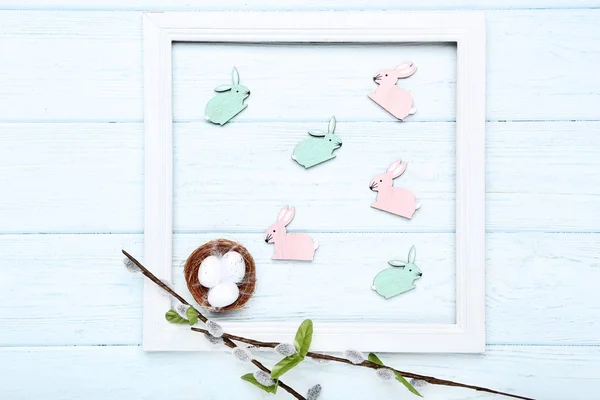 Lapins de Pâques avec petits œufs et branches de saule sur languette en bois — Photo