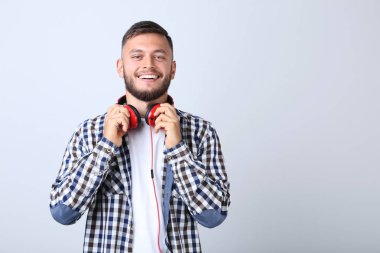 Gri arka plan üzerinde kırmızı kulaklık ile genç adam