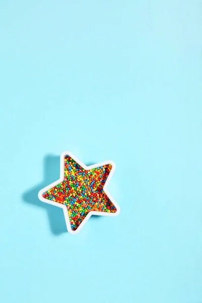 Star with sprinkles on blue background. Minimalism concept