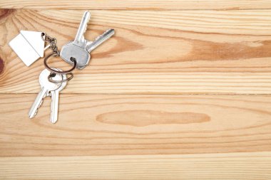 Kahverengi ahşap masa üzerinde ev sembolü ile gümüş tuşları