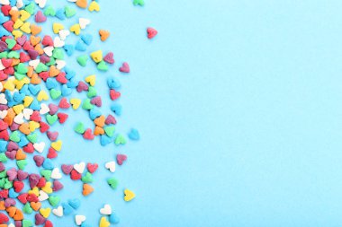 Sprinkles mavi arka plan üzerinde renkli kalp şeklinde