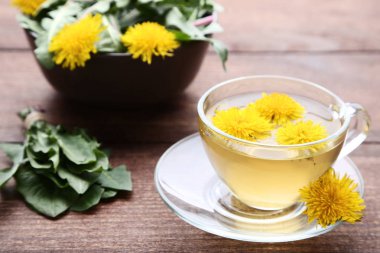 Kahverengi ahşap tabloda çay ile sarı karahindiba