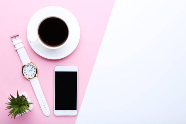 Renkli arka planda bir fincan kahve ve kol saati ile akıllı telefon