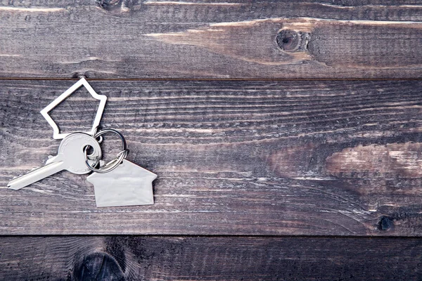 Silver key with house symbol on brown wooden table