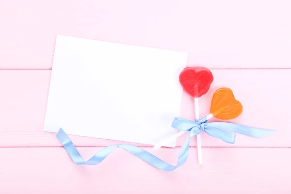 Herzförmige Lutscher Mit Schleife Und Grußkarte Auf Rosa Holztisch — Stockfoto