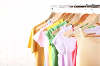 Ahşap askı üzerinde asılı moda giysiler