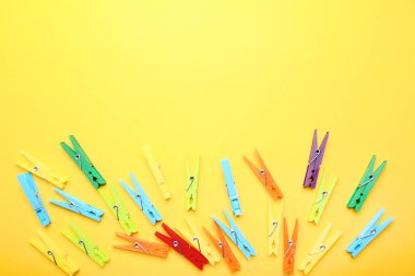 Sarı arka planda renkli plastik clothespins
