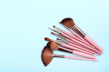 Mavi arka planda makyaj fırçaları seti