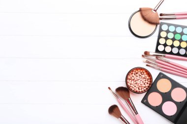 Beyaz ahşap masa üzerinde paletli makyaj fırçaları