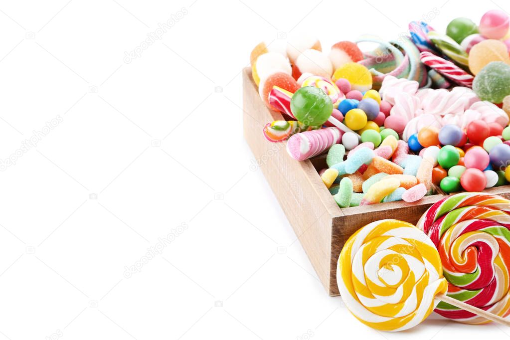 Sweet candies and lollipops in basket on white background