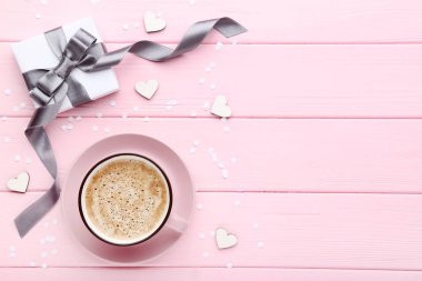 Pembe ahşap masa üzerinde kahve ve beyaz kalpler fincan ile Hediye kutusu
