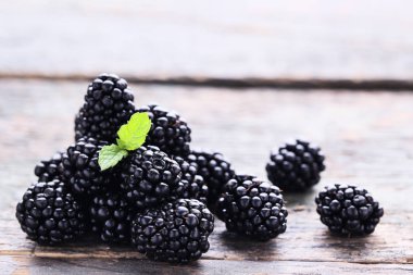 Gri ahşap masada olgun böğürtlen