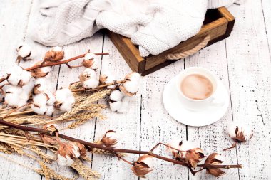 Fincan cofffee ve kazak Beyaz ahşap masa üzerine çiçeklerle pamuk