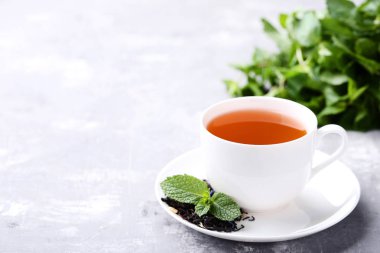 Çay nane ile gri ahşap masa üzerinde yapraklar