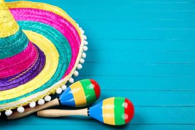Mavi ahşap masa üzerinde Meksika şapka ve maracas