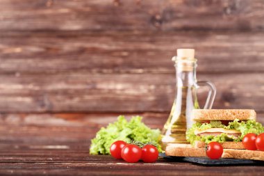 Kahverengi ahşap masa üzerinde taze sebze ile lezzetli sandviç