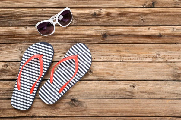 Paar Flip Flops Mit Sonnenbrille Auf Braunem Holztisch — Stockfoto