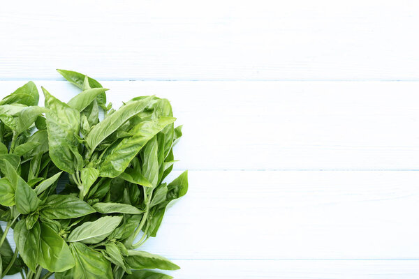 Green basil leafs on wooden table